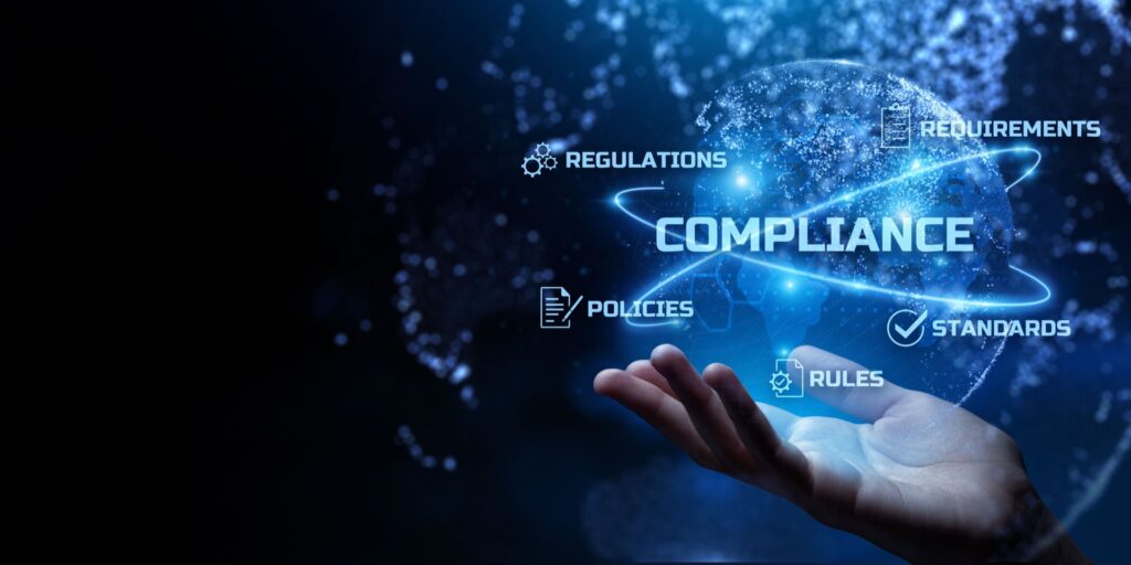 Hand holding technology that says compliance, regulations, policies, requirements and standards