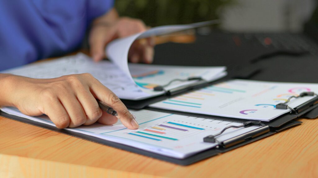 A person going over reports on multiple clipboards